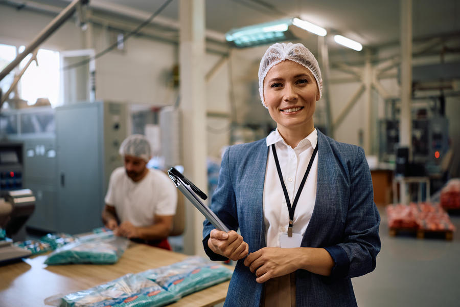 Mulher em frente a uma fábrica de alimentos.